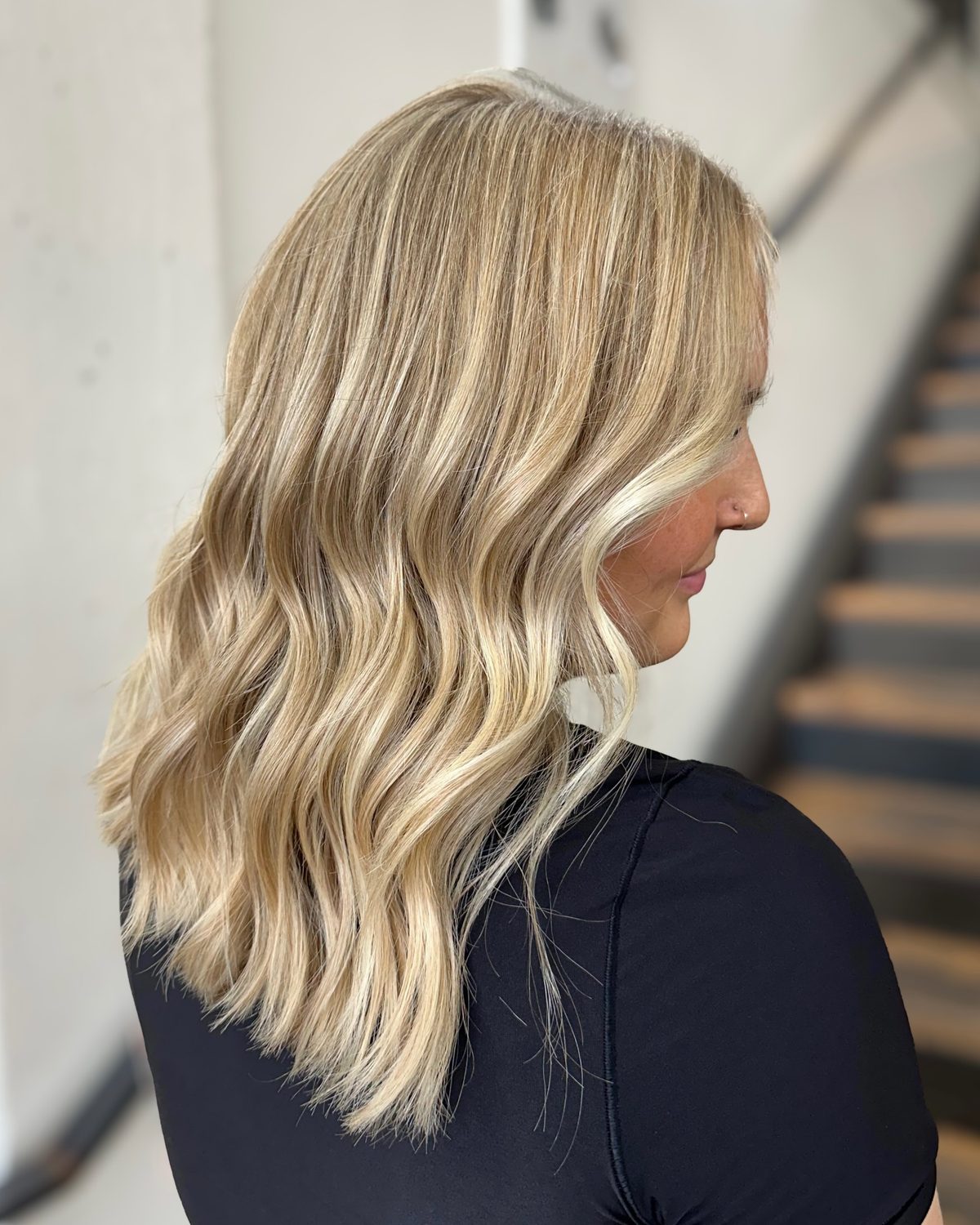 Side view of shoulder-length, sun-kissed blonde balayage with soft waves