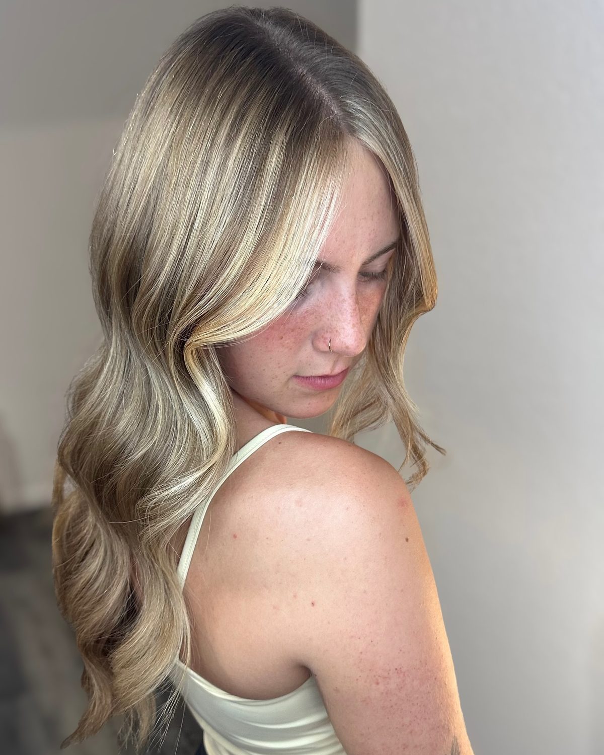Lived-in blonde with a soft shadow root, bright face-framing pieces and long waves